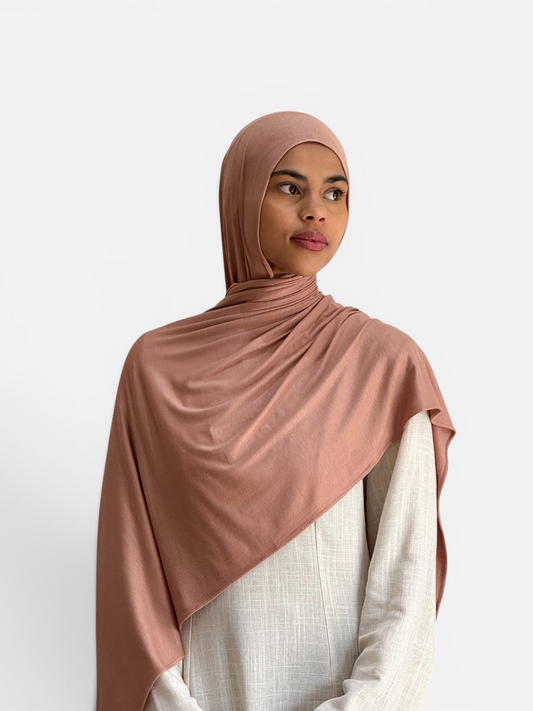 Model wearing a SAHR STUDIOS cinnamon-coloured breathable cotton jersey hijab scarf with a soft sheen.