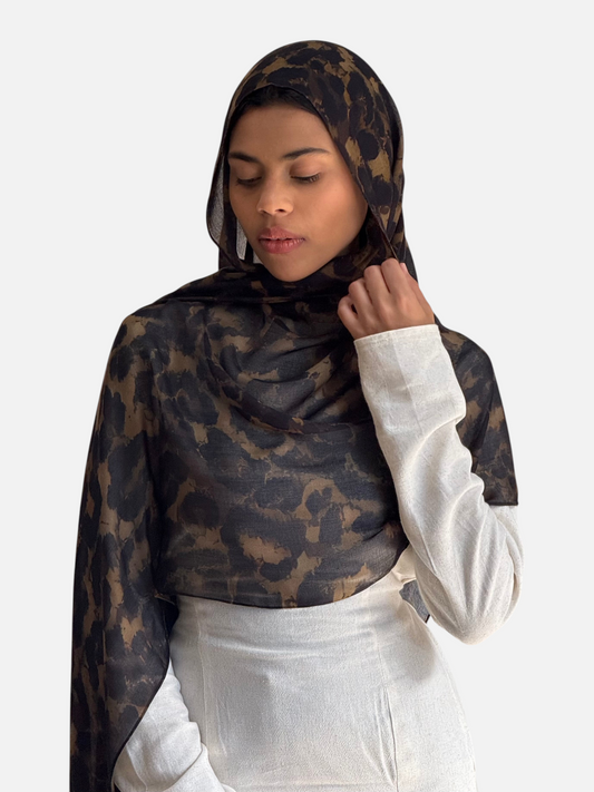 Model wearing a SAHR STUDIOS dark leopard print modal scarf with a soft drape against a neutral background