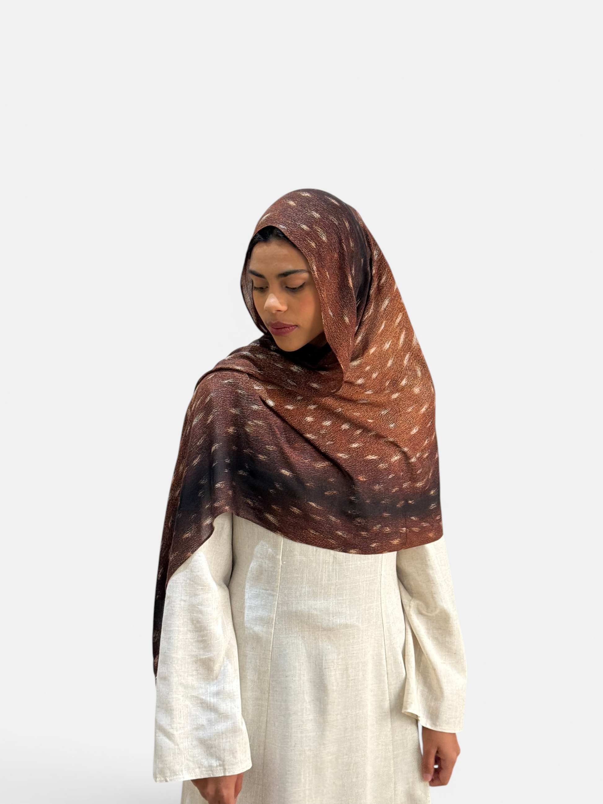 SAHR STUDIOS Premium Modal Bambi scarf in brown with a subtle spotted pattern draped over a model in a beige dress